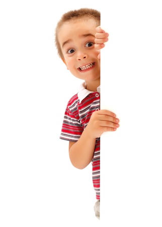 Funny little boy mime scary expression from behind white wallの写真素材