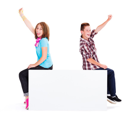 Excited kids cheering while sitting on blank billboardの写真素材