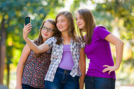 Teenage girls taking selfie by using mobile phoneの写真素材