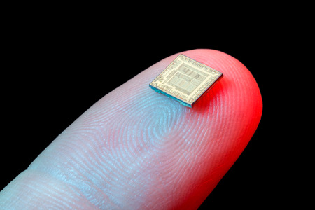 Silicon micro chip on human finger's tipの写真素材