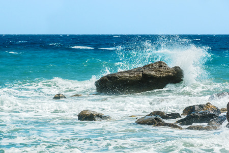 Moderate sea waves hitting the rocks near the beachの写真素材