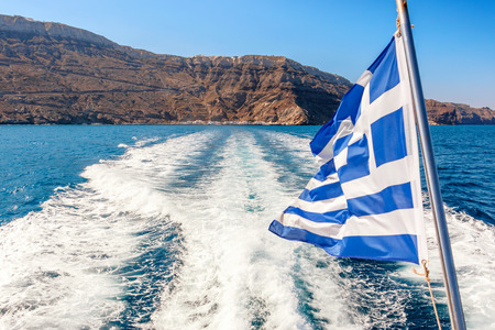 Greek flag waving on the back of a shipの写真素材
