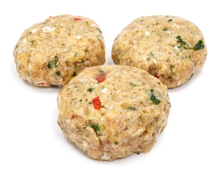 Raw spicy meatballs with herbs and vegetables on white backgroundの写真素材