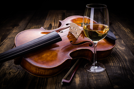 Violin and wine on dark wooden backgroundの写真素材