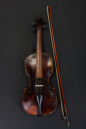 Classical used violin with bow on black backgroundの写真素材
