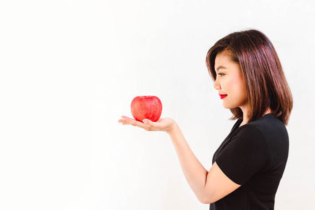 Woman Look at an Apple on Her Hand on White Backgroundの写真素材