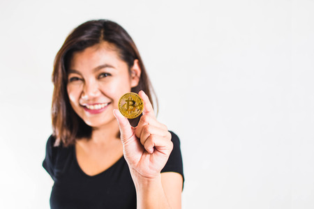 Woman Show Her Golden Bitcoin on White Background; Selective Focus.の写真素材