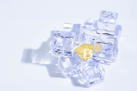 Golden Shining Bitcoin the Top of Cryptocurrency under the Ice Rockの写真素材