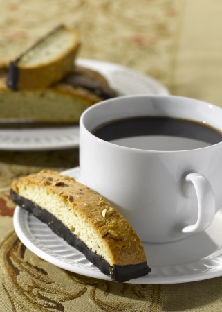 A Biscotti (Italian Biscuit) on a saucer with a cup of coffeeの写真素材