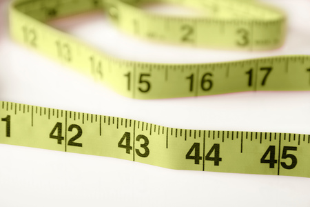 Measuring tape on white with slight shadows.