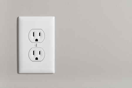 A white home electrical outlet on a light grey wall.の写真素材