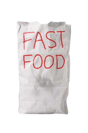 A small white paper bag, wrinkled with some grease spots, with "FAST FOOD" written on it in big red letters, isolated on whiteの写真素材