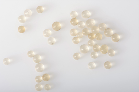 Loose silica gel beads scattered on white.の写真素材