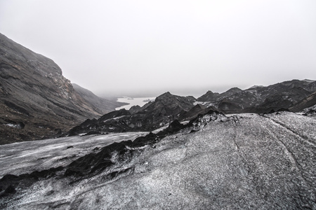 SÃ³lheimajÃ¶kull Glacier in Iceland showing ash piles on the ice, looking back toward the path onto the glacier.の写真素材