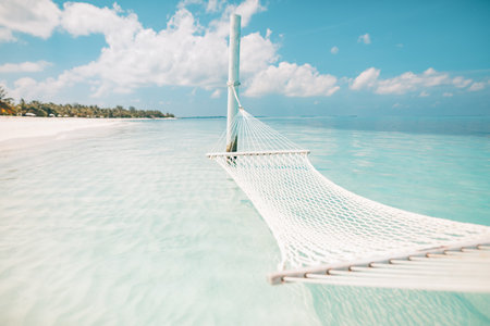 White hammock with clear blue sea and island in background. Perfect honeymoon or couple getaway...