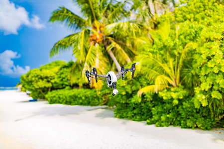 Professional drone quadcopter with digital camera on tropical beach. Taking footage of honeymoon...