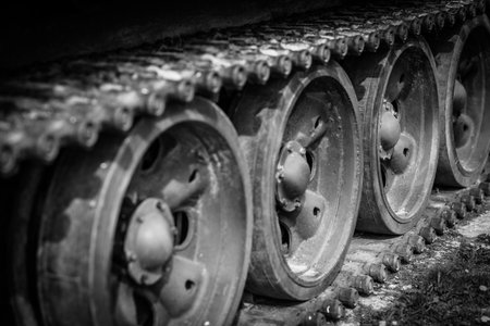 Detail shot with old tank tracks and wheels. Dramatic black and white world war concept. Monochrome tank detailの写真素材