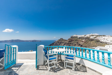 View of Greece Santorini, caldera outdoor restaurant, beautiful sea bay white architecture. Sunny travel and tourism landscape background. Santorini island, Greeceの写真素材