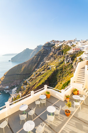 Romantic Santorini island during sunset, Greece, Europe. Amazing evening view of Fira, caldera, volcano of Santorini, Greece, soft sunlight over beautiful terrace, restaurant viewの写真素材