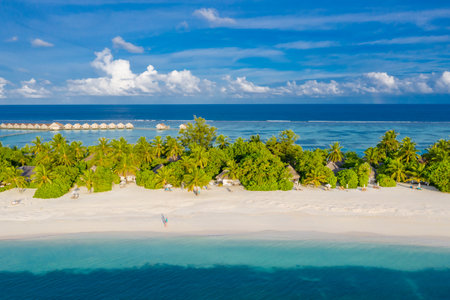 Luxury resort island in Maldives water villas background blue sea sky, aerial view. Nature landscape, tropical beach, sunny coast of Maldives island. Beautiful weather from droneの写真素材