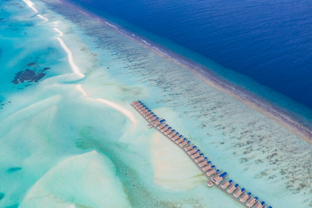 Aerial view on Maldives island. Beautiful sea and coral reef luxury water villas. Tropical resort, amazing exotic landscape. Summer vacation beach and holiday. Tourism destinationの写真素材