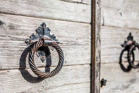 Old wooden door with iron knocker in the shape of a ring