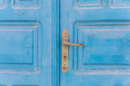 Close up of old wooden door with blue door knob, Greece.の写真素材