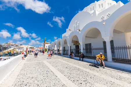 05.11.21 - Santorini, Fira, Greece: capitol town of Santorini. Main square, people walking on traditional white architecture, moody streets, summer day. Luxury vacation in Europeのeditorial素材