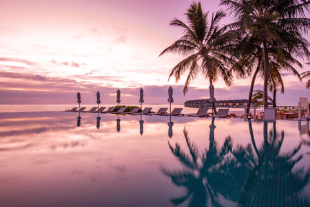 Luxury swimming pool, beach bed umbrellas, tranquil lifestyle. Exotic tropical landscape copy space, summer exotic leisure for vacation holidays. Beautiful poolside and sunset skyの写真素材