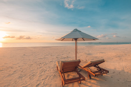 Relaxing sunset beach, summer vacation and holiday concept. Beach sunset view loungers and umbrella. Luxury travel landscape, exotic nature background. Paradise island viewの写真素材