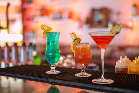 Exotic cocktails, mojito-cocktail in glass glasses with straws and fruits and blurred bar...