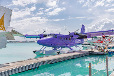 Seaplane parking next to floating wooden pier, floating dock, Mldives. Transmaldivian airways, world largest seaplane company. Male, Maldives - 14.08.21のeditorial素材
