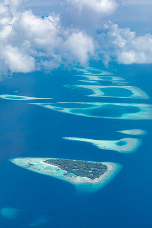 Aerial view of coral reefs in Maldives islands. Tropical aerial landscape. Luxury summer vacation...
