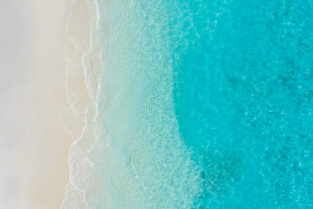 Summer seascape beautiful waves, blue sea water in sunny day. Top view from drone. Sea aerial, amazing tropical nature background. Beautiful bright sea waves splashing beach sandの写真素材