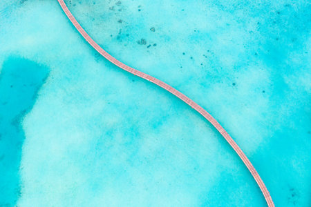 Abstract background of turquoise water with wooden pier path in the middle. Calm azure sea waterの写真素材