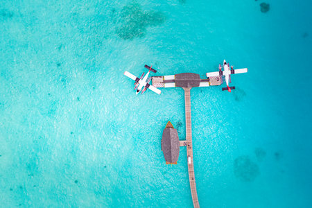 Beautiful aerial view of Maldives shore, pier villa seaplane top view, wooden boat Dhoni tropical beach. Turquoise  sea. Luxury travel vacation. Amazing aerial landscapeの写真素材