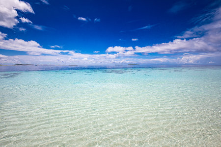 Peaceful nature environment, water sky concept. Beautiful beach with white sand, turquoise ocean water and blue sky with clouds in sunny day. Natural background for summer vacationの写真素材
