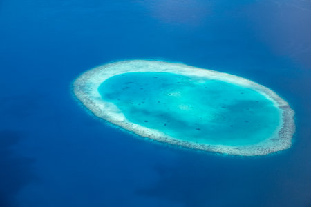 Tropical islands and atolls in Maldives from aerial view. Famous travel destination and luxury vacation summer holiday. Aerial landscape of blue sea resorts. Beautiful natureの写真素材