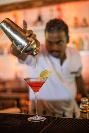 Expert barman is making cocktail at night club. Vintage portrait of bartender creating cocktails at bar. Close up of alcoholic beverage preparation. 08.17.21 - Noonu atoll Maldivesのeditorial素材