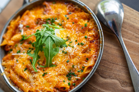 Italian pasta skillet dish. Tasty delicious pasta meal is made penne pasta, fresh tomato sauce sausage. This italian inspired comfort food is cooked and served in cast iron skilletの写真素材