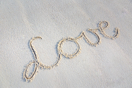 Love message written in sand. Tropical white sand, abstract drawing and sign