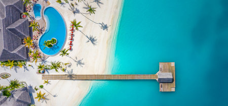 Beautiful aerial view poolside resort beach wooden pier jetty. Luxurious tropical beach landscape, swimming, deck chairs beds, umbrellas. Tropical beach, aerial drone top viewの写真素材