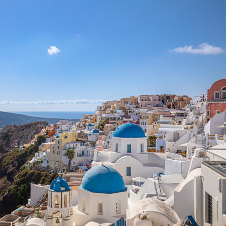 Beautiful Oia town on Santorini island, Greece. Traditional white architecture Greek churches blue domes over the Caldera. Luxury summer travel vacation destination, holiday sceneの写真素材