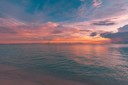 Relaxing seascape, sunset colorful sky with water reflection. seaside, coast, shore of ocean lagoon with bright golden yellow light. Tropical nature pattern, horizon and cloudy skyの写真素材