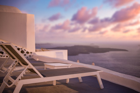 24.07.21. Santorini island, Oia sunset caldera, two sun beds, loungers, amazing sun rays sea view horizon colorful sky calm relax. Luxury Greece travel vacationのeditorial素材