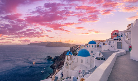 Beautiful panorama of Santorini island in Greece at sunrise dramatic sky. Stunning Oia cityscape, sunset colors sky blue domes white architecture. Amazing travel vacation landscapeの写真素材
