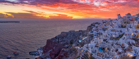 Oia sunset, Santorini island. Famous travel landscape, luxury vacation destination. Beautiful view fabulous picturesque village colorful sky, traditional white houses and windmillsの写真素材
