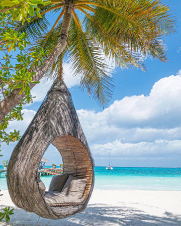 Tropical beach background as summer landscape beach swing or hammock close to water villas, coast white sand and calm sea for beach banner. Leisure vacation and summer holidayの写真素材