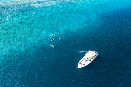 Beautiful turquoise ocean water boat, aerial drone seascape. Tropical sea waves, amazing aerial coral reef. People recreational outdoor activity, swimming snorkeling diving tourismの写真素材