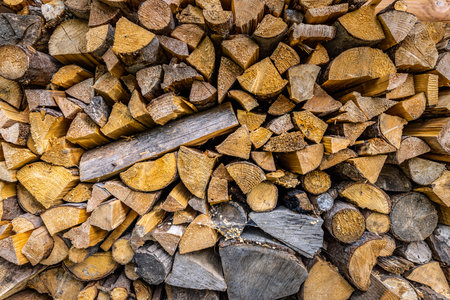 Dry chopped firewood logs. Wooden pile texture. Abstract autumn winter countryside, textured firewood background of chopped wood for kindling heating house, stacked woodpileの写真素材